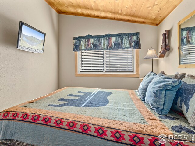 bedroom featuring vaulted ceiling and wood ceiling