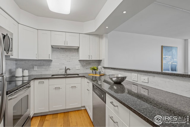 kitchen featuring sink, white cabinets, stainless steel appliances, and light hardwood / wood-style flooring