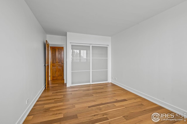 unfurnished bedroom featuring hardwood / wood-style floors and a closet