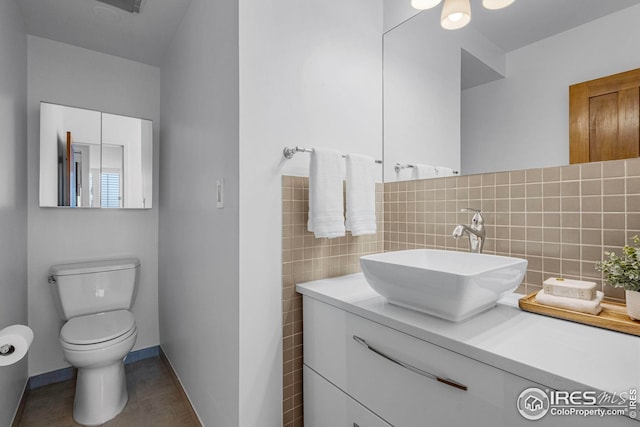 bathroom featuring decorative backsplash, vanity, tile walls, tile patterned flooring, and toilet