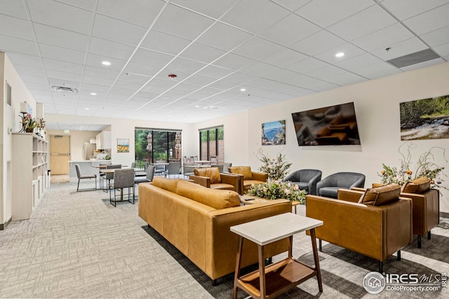 carpeted living room featuring a paneled ceiling