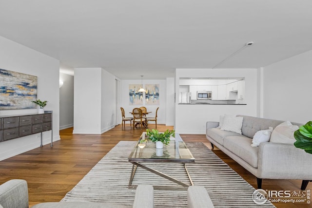 living room with hardwood / wood-style floors and a notable chandelier