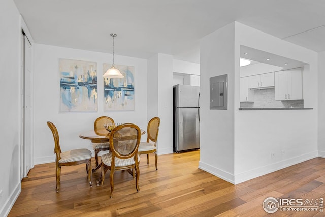 dining area featuring electric panel and light hardwood / wood-style flooring