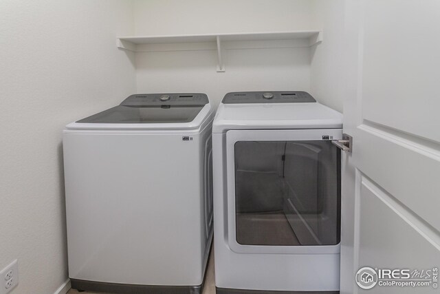 clothes washing area with separate washer and dryer