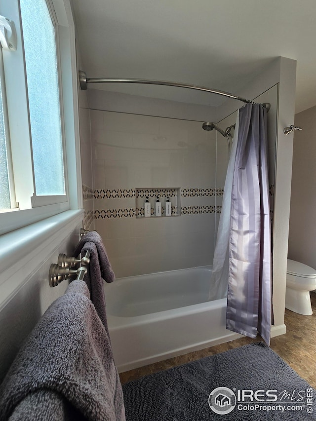 bathroom with hardwood / wood-style floors, shower / bathtub combination with curtain, and toilet