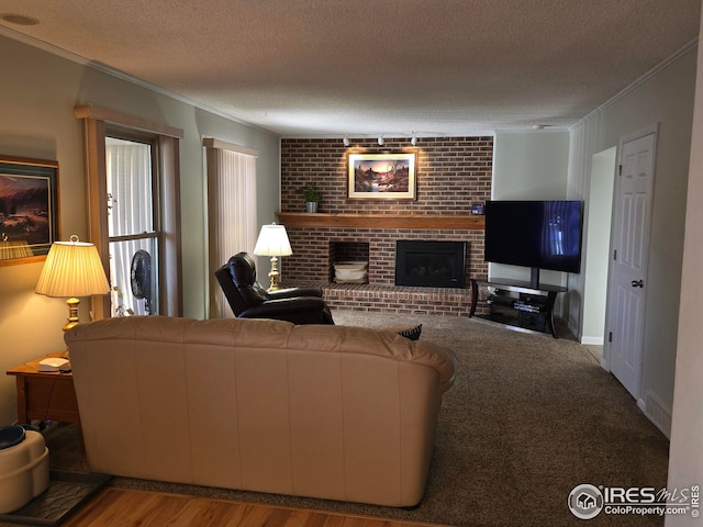 living room featuring a fireplace, a textured ceiling, light hardwood / wood-style floors, and ornamental molding