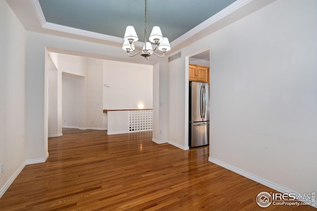 unfurnished dining area featuring ornamental molding, dark wood-type flooring, and a chandelier