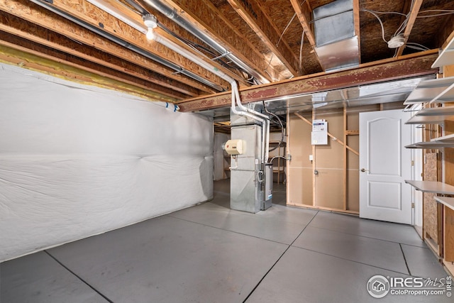 basement with tile patterned flooring and heating unit