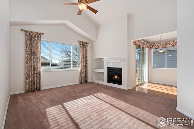 unfurnished living room featuring ceiling fan, carpet flooring, vaulted ceiling, and built in features