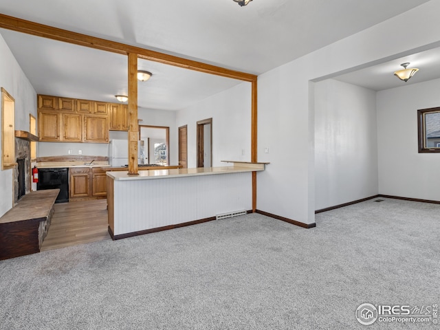 kitchen with kitchen peninsula, white refrigerator, light colored carpet, and dishwasher