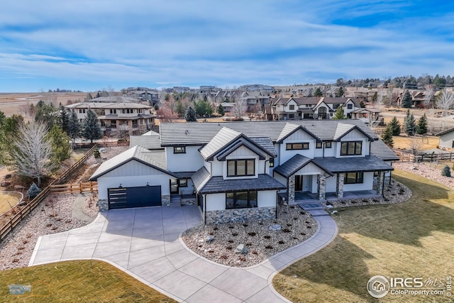 view of front of house with stucco siding, fence, a residential view, a front yard, and a garage