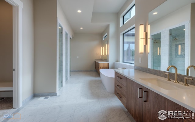 full bathroom with vanity, baseboards, a freestanding tub, recessed lighting, and a shower stall