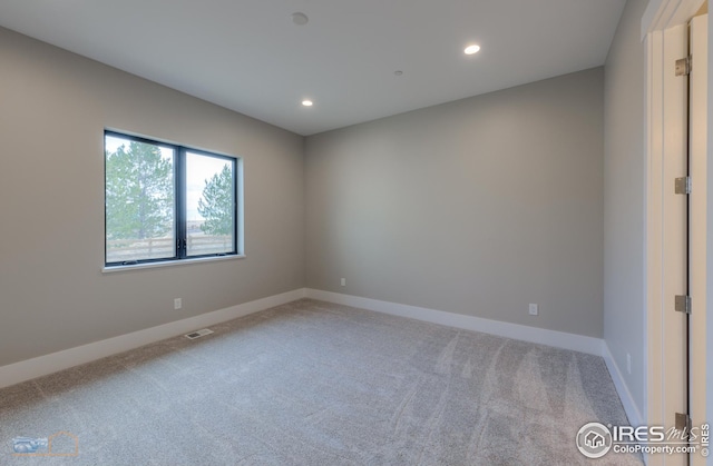 empty room featuring recessed lighting, visible vents, light colored carpet, and baseboards
