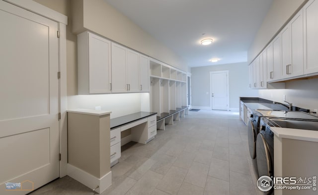 kitchen with washer and dryer, white cabinets, and built in study area