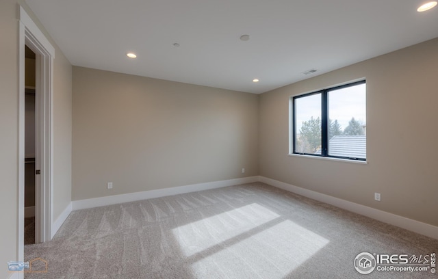 carpeted spare room featuring recessed lighting, visible vents, and baseboards