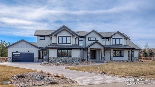 view of front of home featuring a garage, stone siding, concrete driveway, and a front yard