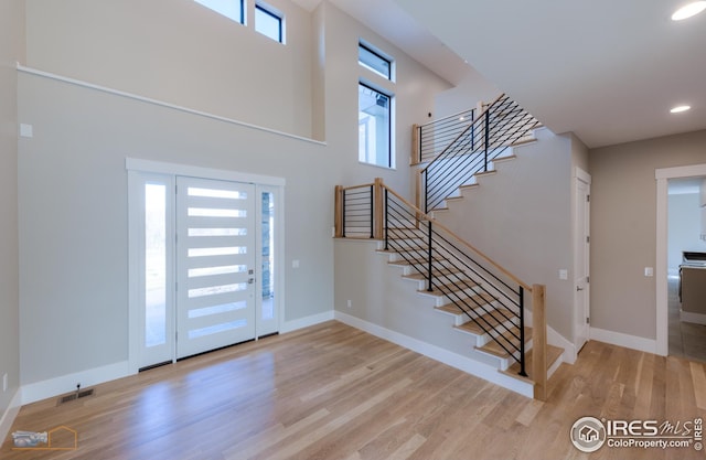 foyer featuring a wealth of natural light, baseboards, and wood finished floors