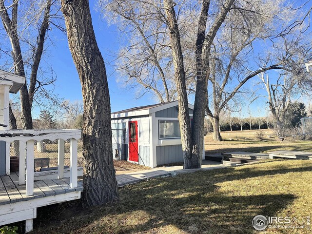 view of home's exterior with a lawn, a storage shed, and a deck