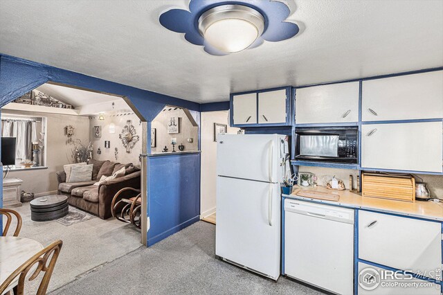 kitchen featuring vaulted ceiling, a textured ceiling, white cabinets, and white appliances