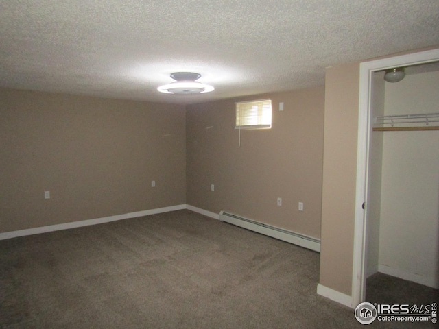 basement featuring carpet flooring, a textured ceiling, and a baseboard heating unit