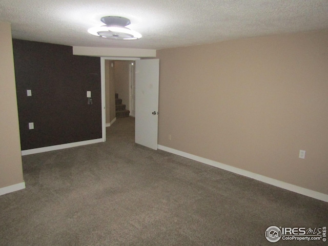 carpeted spare room with a textured ceiling