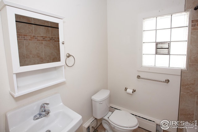 bathroom featuring a baseboard heating unit, sink, and toilet