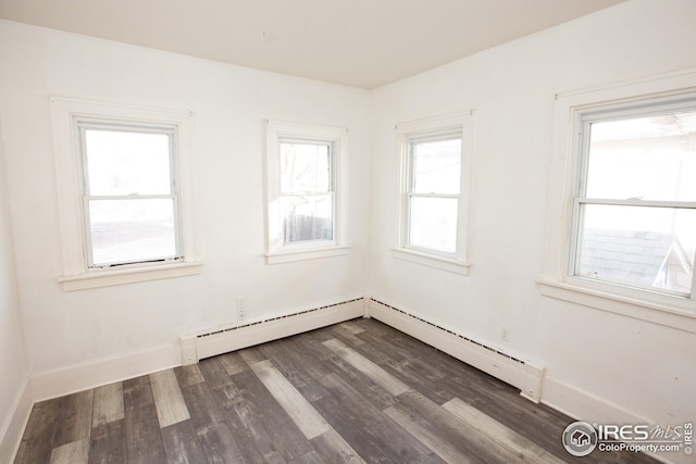 spare room featuring dark hardwood / wood-style flooring and a baseboard heating unit