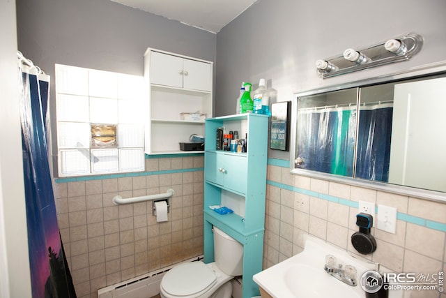 bathroom featuring toilet, sink, tile walls, and a baseboard heating unit