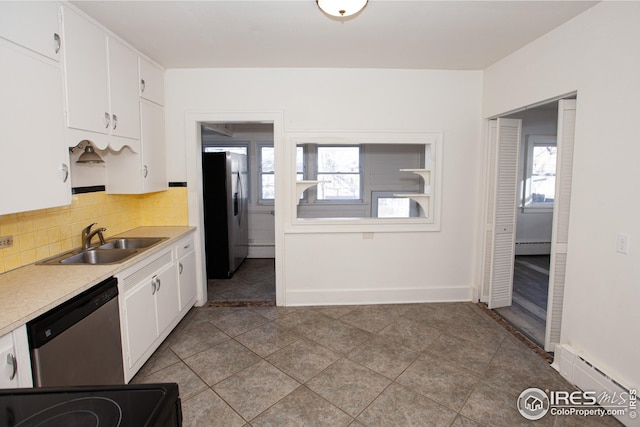 kitchen with stainless steel appliances, sink, white cabinets, and baseboard heating