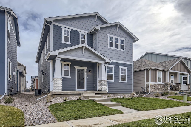 craftsman-style house featuring cooling unit and a front lawn