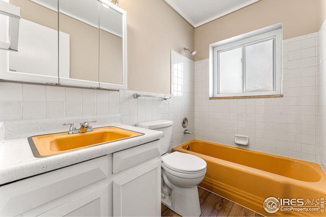 full bathroom with wood-type flooring, toilet, vanity, tile walls, and tiled shower / bath