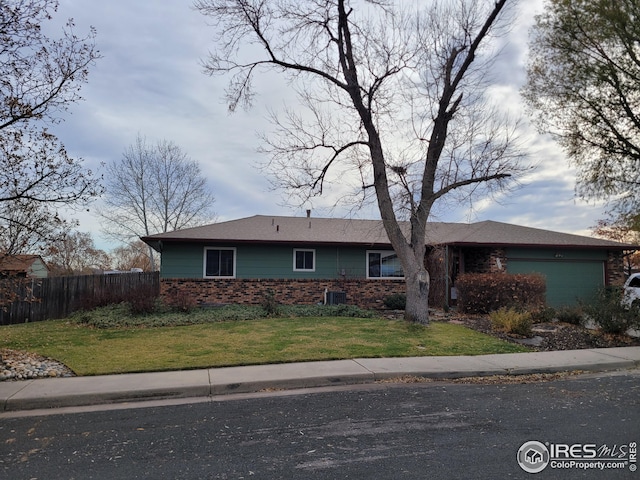 ranch-style house featuring a front yard and a garage