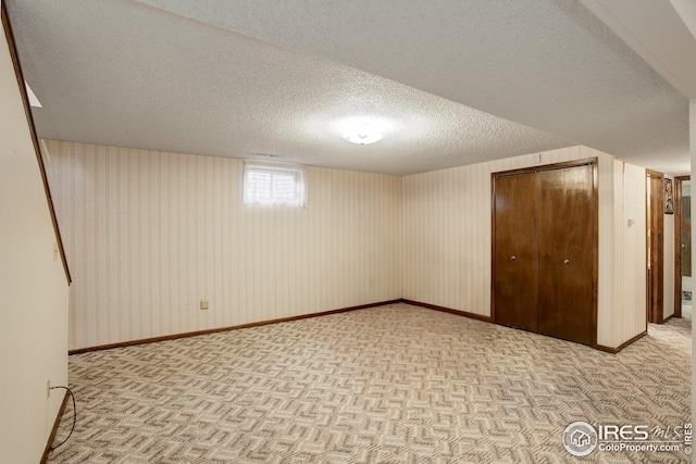 basement with a textured ceiling and light carpet