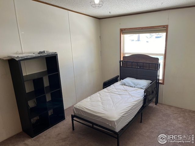 carpeted bedroom with a textured ceiling and ornamental molding