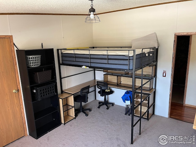carpeted bedroom with lofted ceiling, a textured ceiling, and ornamental molding