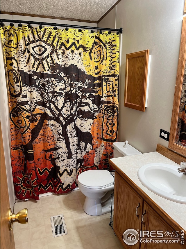 bathroom featuring vanity, a textured ceiling, and toilet