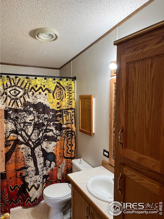 bathroom featuring crown molding, vanity, a textured ceiling, and toilet