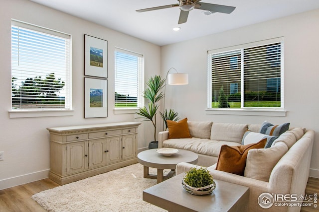 living room featuring light hardwood / wood-style flooring, a wealth of natural light, and ceiling fan