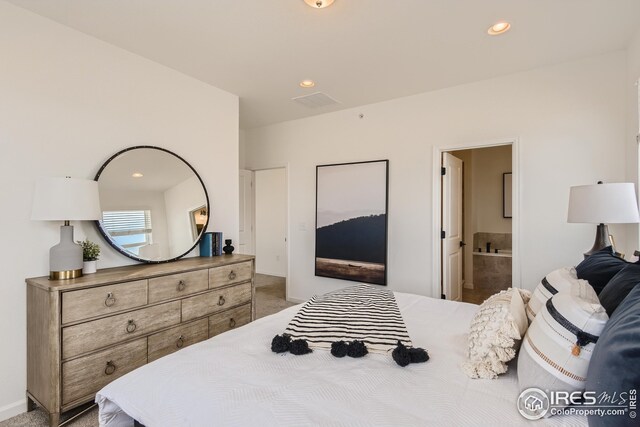 carpeted bedroom featuring ensuite bath