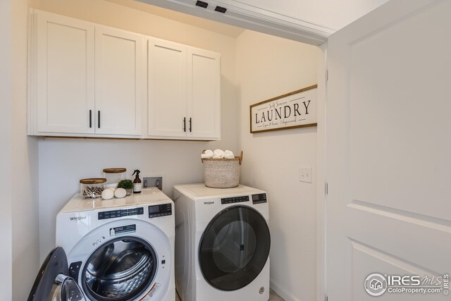 laundry room featuring cabinets and washer and dryer