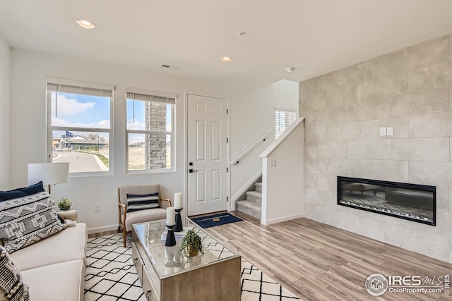 living room featuring light wood-type flooring and a fireplace