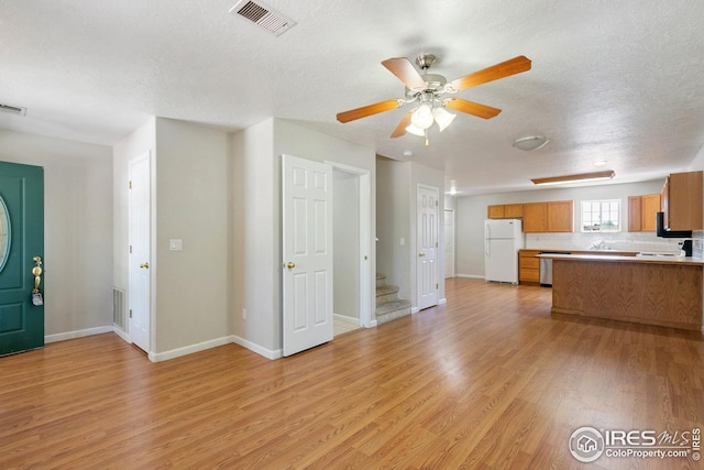 interior space featuring ceiling fan, a textured ceiling, and light wood-type flooring