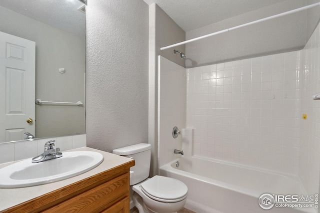 full bathroom featuring vanity, tub / shower combination, toilet, and a textured ceiling