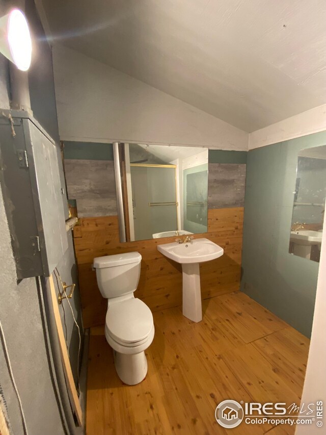 bathroom featuring vaulted ceiling, toilet, hardwood / wood-style flooring, and sink