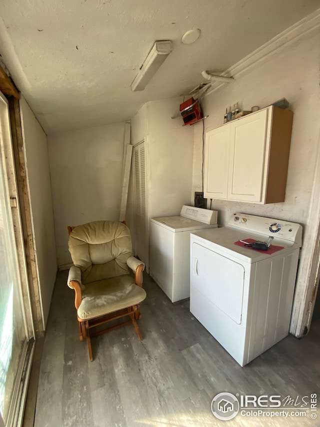 laundry area featuring cabinets, washer and dryer, and hardwood / wood-style flooring