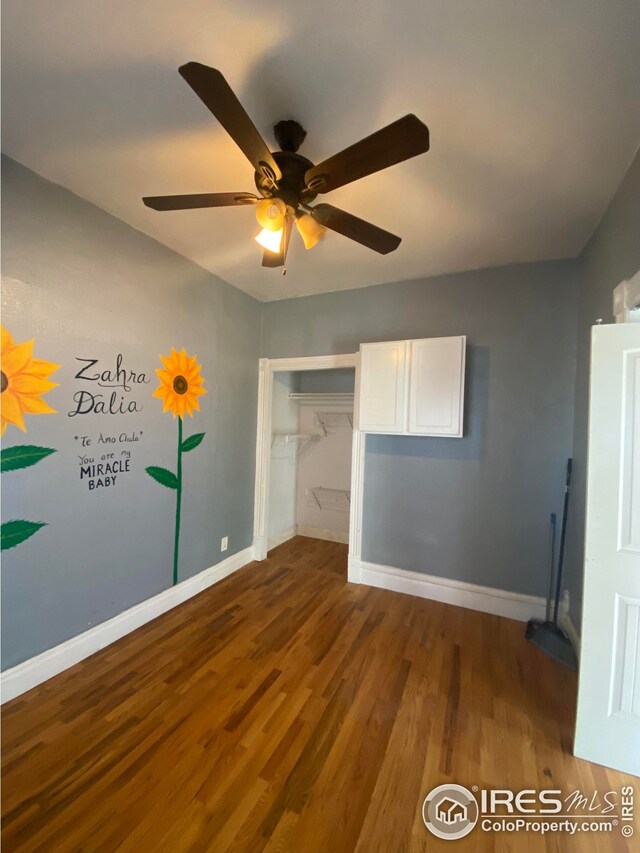 unfurnished bedroom with ceiling fan, a closet, and hardwood / wood-style flooring