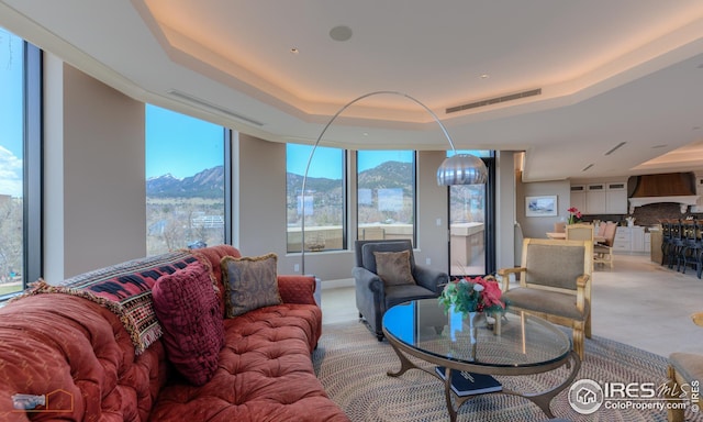 living room featuring a mountain view and a tray ceiling