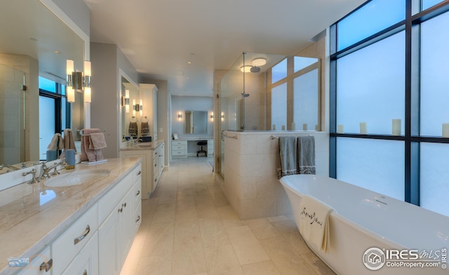 bathroom featuring a wall of windows, vanity, and shower with separate bathtub