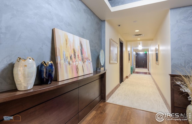 corridor with a skylight and hardwood / wood-style floors