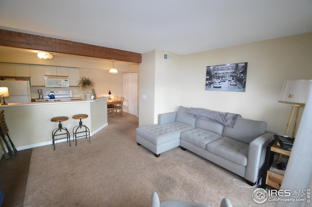 carpeted living area featuring visible vents and beamed ceiling